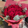 Classic spiral bouquet of red roses with eucalptus.